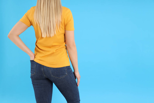 Женщина в оранжевой футболке на синем фоне - Фото, изображение