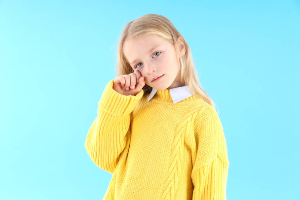 Resentful little girl in sweater on blue background - Photo, image