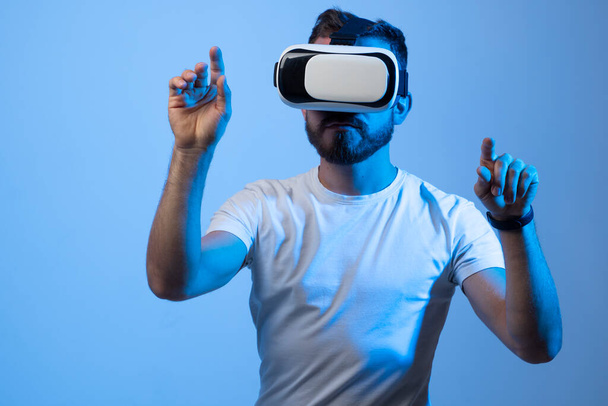 Model young man with beard in glasses of virtual reality. Augmented reality, science, future technology, VR. Futuristic 3d glasses with virtual projection. - Photo, Image