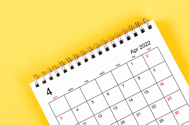 Close-up abril 2022 calendário de mesa no fundo amarelo. - Foto, Imagem