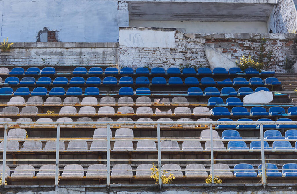 Altes Stadion-Podium mit weißen und blauen Plastiksitzen. - Foto, Bild