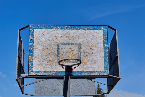 Régi és vintage kosárlabda háttámla és karika. Kosárlabda karika hátterében kék ég és fehér felhők. - Fotó, kép