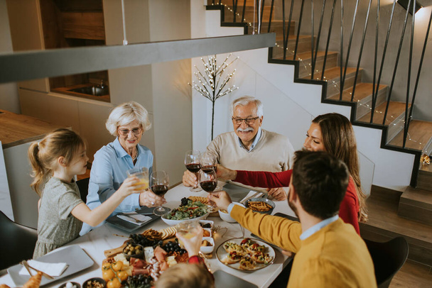 Szczęśliwa rodzina przy kolacji z czerwonym winem w domu - Zdjęcie, obraz