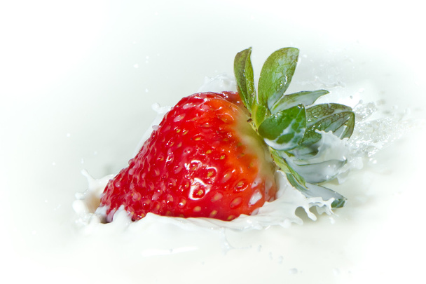 Strawberry splashing into milk - Foto, afbeelding