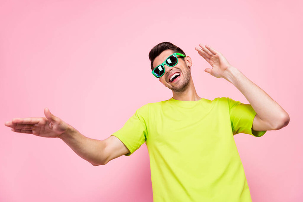 Photo of funky brunet hairdo millennial guy dance wear eyewear green t-shirt isolated on pink color background - Zdjęcie, obraz