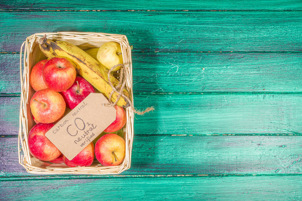 Producto de concepto neutro en carbono, libre de CO2. Manzanas de frutas de granja orgánicas naturales, con etiqueta CO2 neutral verificada, en escritorio de madera en tienda de granja - Foto, Imagen