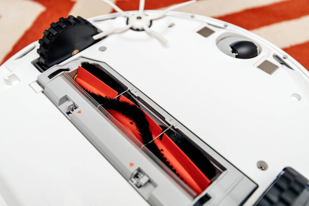 Крупный план нового роботизированного пылесоса Robovac показывающий часть щетки и колеса - Фото, изображение