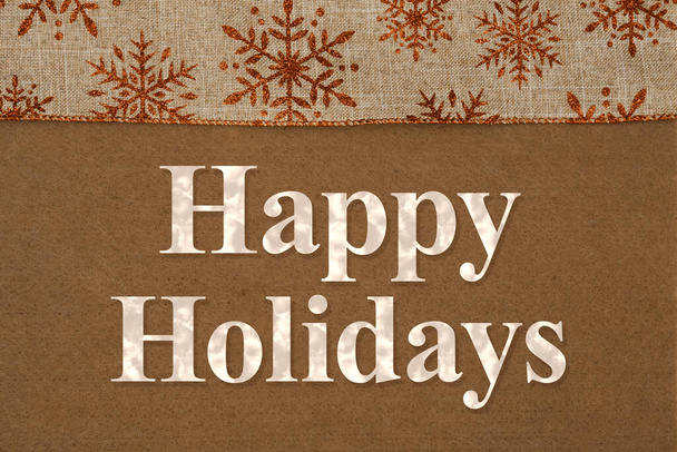 Happy Holidays begroeting met bruine sneeuwvlokken op vilt materiaal - Foto, afbeelding