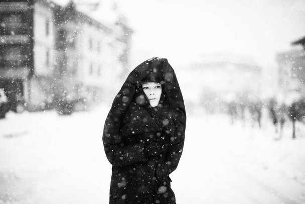 woman in puffer coat posing in snowy scene, black and white - Photo, Image