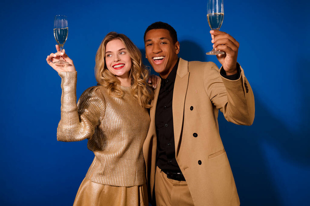 Guy and girl hugged raising glasses of champagne - Foto, Imagem