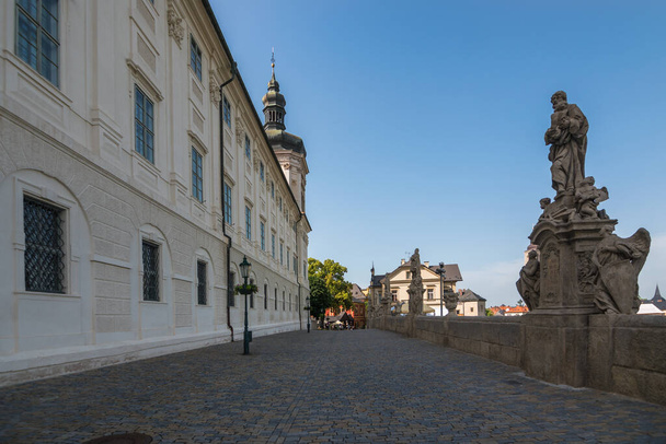 Kutna Hora, Czech Republic, June 2019 - Άποψη του κολλεγίου Jesuit και της διάσημης ψευδογέφυρας με τα 13 αγάλματα αγίων που μοιάζουν με τη Γέφυρα του Καρόλου της Πράγας        - Φωτογραφία, εικόνα