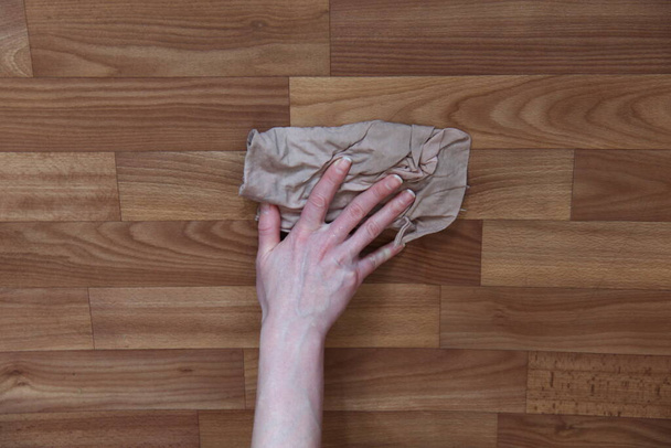 Рука жінки миє паркетну підлогу ганчіркою
 - Фото, зображення