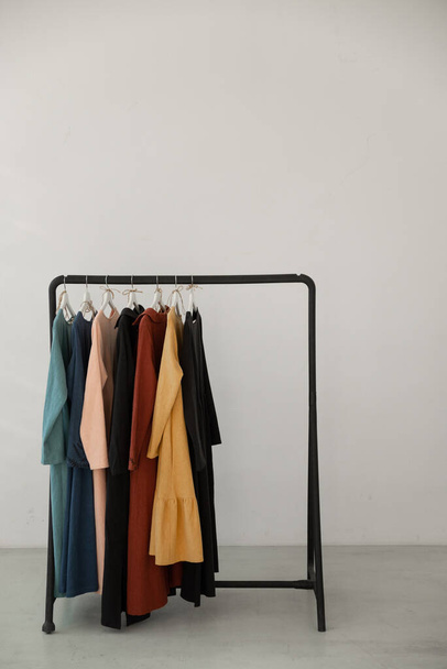 Minimalistic rack with clothes on white studio background.  - Фото, изображение