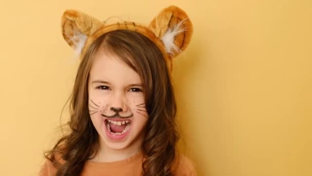Söpö tyttö, jolla on maalatut kasvot tiikerin valepuvussa murisee suu auki. Lapsella on numero 2022 käsissään. Tiikerin uusi vuosi itäisen kalenterin mukaan. - Materiaali, video