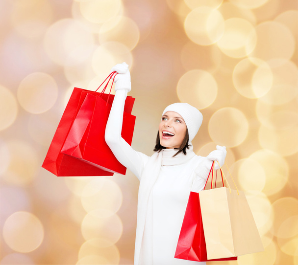 smiling young woman with red shopping bags - Foto, Bild