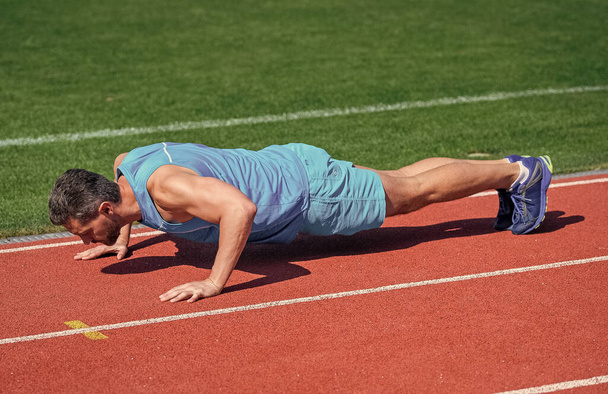 muscular man stand in plank making push up on sport training, energy - Foto, afbeelding