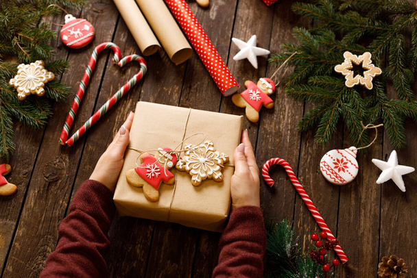 Wrapped παρόν, χειμωνιάτικα μπισκότα και μπισκότα σε διάφορα εορταστικά σχήματα, ξύλινο υπόβαθρο, Καλά Χριστούγεννα και Καλή Πρωτοχρονιά έννοια - Φωτογραφία, εικόνα