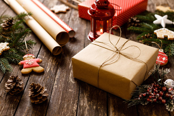 Χειμερινά δώρα διακοπών και σπιτικά νόστιμα μπισκότα με άχνη ζάχαρη στο ξύλινο τραπέζι μαζί με κόκκινο εορταστικό φανάρι και άλλα χειμερινά κίνητρα, Καλά Χριστούγεννα και Καλή Χρονιά - Φωτογραφία, εικόνα