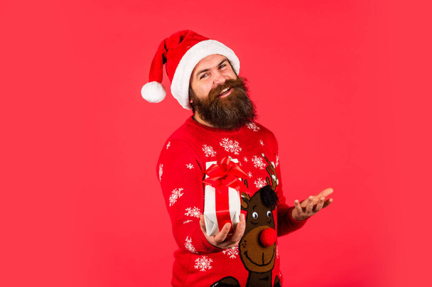 Ho Ho Ho. cheerful man with beard in santa claus hat. brutal man hold present box. bearded hipster in xmas sweater. christmas online shopping. winter holiday party. mature guy celebrate new year - Fotografie, Obrázek