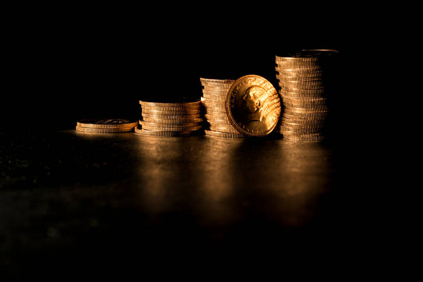 "Stack Of Gold Coins Over Black Background". Изображение. - Фото, изображение