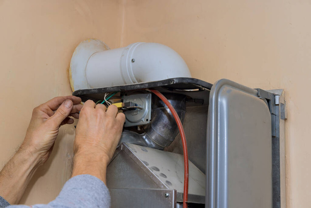 Mantenimiento del calentador de agua de gas de reparación con un técnico de servicio una caldera de gas - Foto, Imagen
