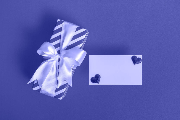 Caja de regalo con tarjeta en blanco y corazones sobre un fondo muy peri. Concepto de San Valentín. De cerca. - Foto, imagen