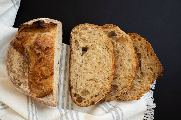 Siyah arka planda taze dilimlenmiş tahıllı ekmek. İki dilim dilimlenmiş ekmek. Yukarıdan görüntüle. - Fotoğraf, Görsel