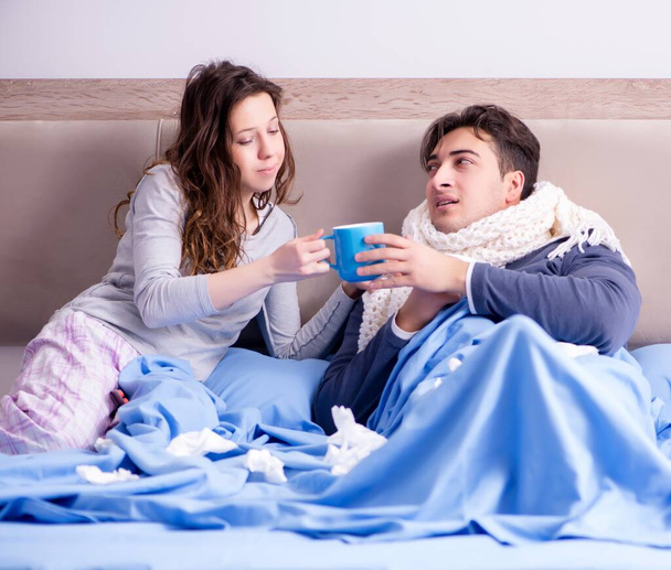 Wife caring for sick husband at home in bed - Фото, зображення