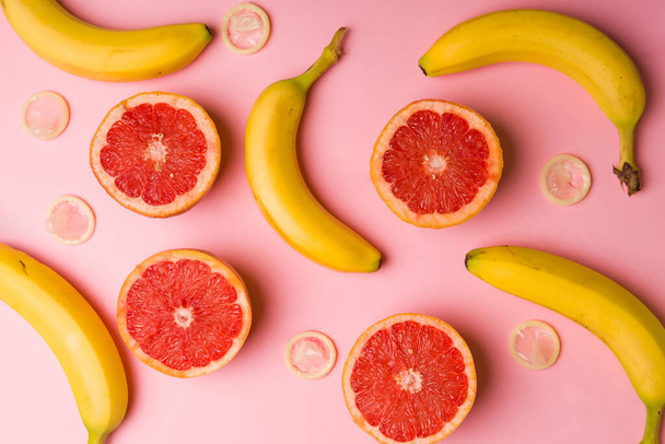 Bevordering van seksuele voorlichting. Patroon van bananen, grapefruit en condooms om veilig te vrijen - Foto, afbeelding