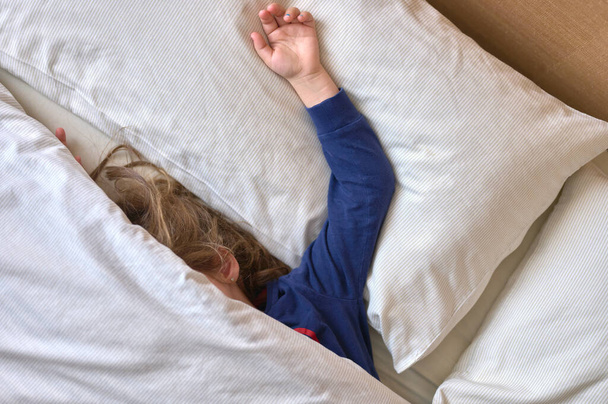 detal dziewczyny śpiącej w łóżku pokrytym kołdrą - Zdjęcie, obraz