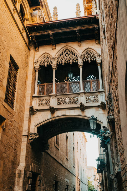 Ancient building - Pont del Bisbe Bishop Bridge alley in old part of Barcelona - Gothic Quarter. Popular travel destination. - Photo, image