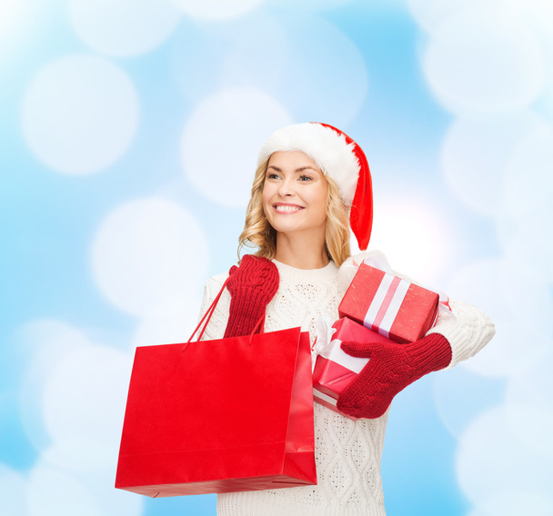 smiling young woman in santa helper hat with gifts - Photo, image