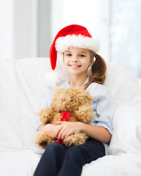 smiling girl in santa helper hat with teddy bear - Fotoğraf, Görsel