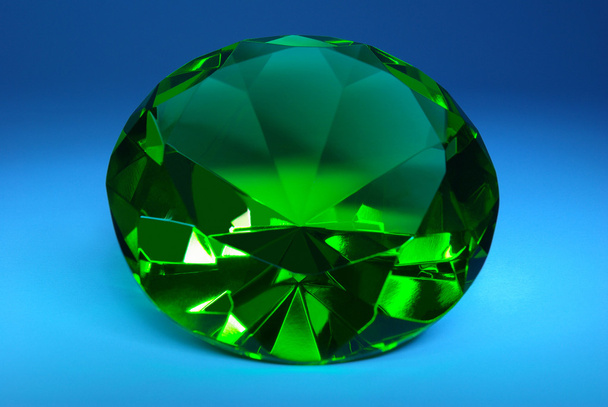 Green emerald on a dark blue background - Photo, Image