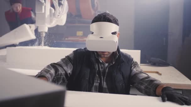 Handwerker mit VR-Brille arbeitet mit Plastikblock - Filmmaterial, Video