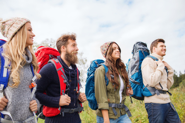group of smiling friends with backpacks hiking - Zdjęcie, obraz
