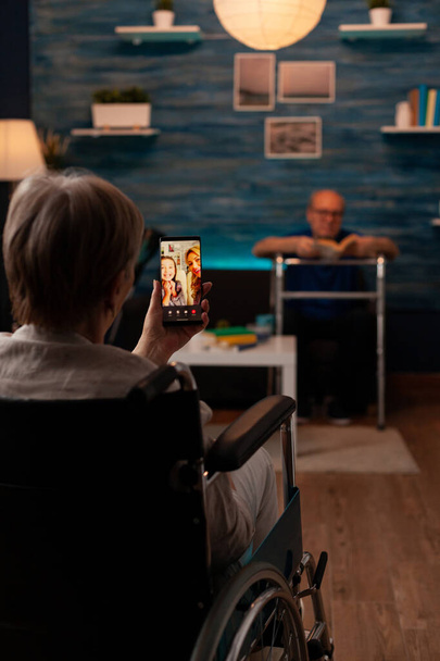 У віці жінка з обмеженими можливостями тримає смартфон для відеодзвінків
 - Фото, зображення