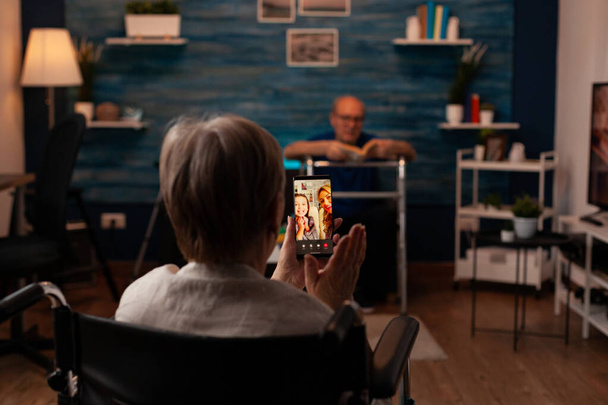 Osoby starsze niepełnosprawne korzystające z połączenia wideo na smartfonie - Zdjęcie, obraz