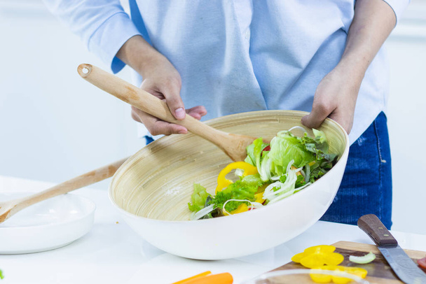 Женщина готовит овощной салат для диеты. - Фото, изображение