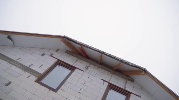 Goła fasada i niedokończony dach domu przed mglistym niebem - Materiał filmowy, wideo