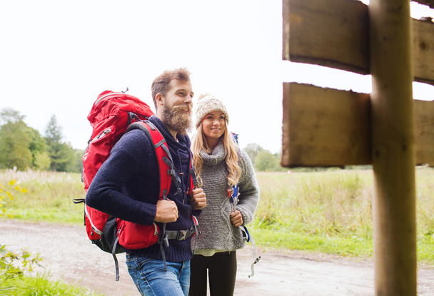 smiling couple with backpacks hiking - Fotografie, Obrázek