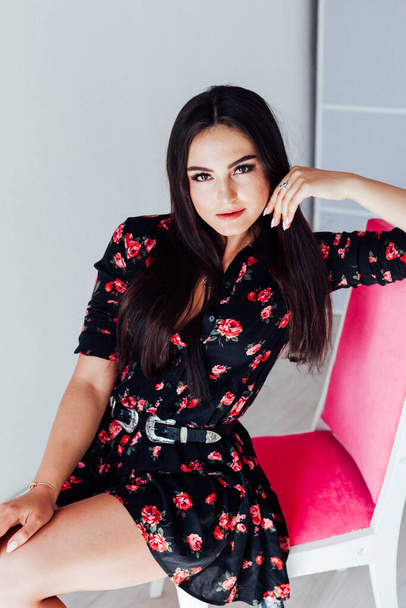 beautiful brunette woman in black dress with flowers - Photo, Image