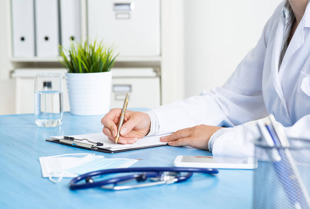Doctor filling patient history list at clipboard - Photo, Image