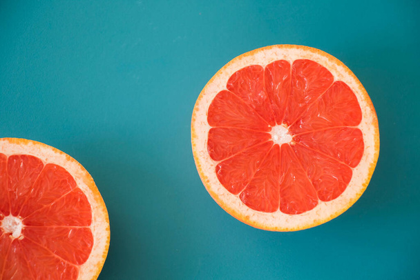 Sliced grapefruit on the blue background, cut grapefruit - Фото, изображение