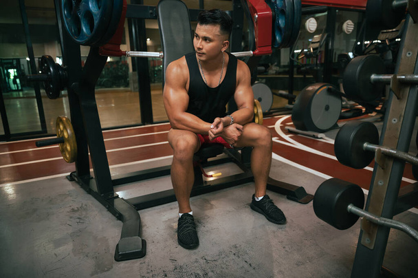 Portré fitness férfi súlyzókkal a tornateremben - Fotó, kép