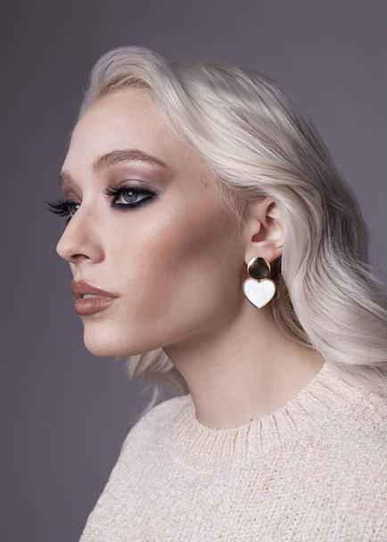 beautiful girl with evening makeup and heart-shaped earrings - Zdjęcie, obraz