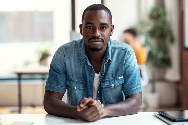 Portrait of afro-american business man entrepreneur looking at camera while working in a modern startup. - Foto, Imagen
