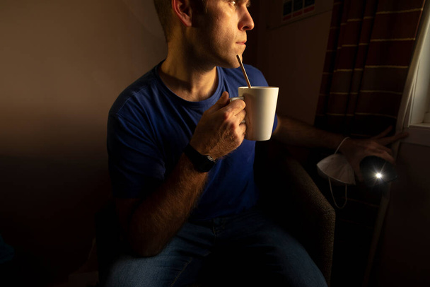 Mirando desde la ventana, cómo el tiempo se desvanece, se aísla, bebiendo un poco de té en una habitación de hotel, cerca del aeropuerto de Manchester, Reino Unido, mientras espero los resultados de una prueba covid-19 - Foto, Imagen