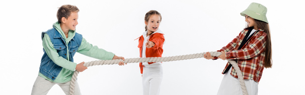 enfant préadolescent regardant des amis tirant la corde tout en jouant remorqueur de jeu de guerre isolé sur blanc, bannière - Photo, image