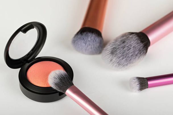 Picture of rose gold blush and makeup brush on white background - Фото, изображение